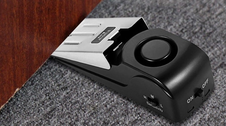 The EMDMAK a-001 door stop alarm, wedged under a door.