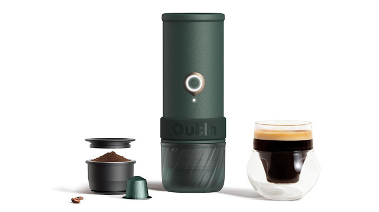 OutIn Mino Espresso Machine showing the coffee grinds, and mug alongside the portable machine