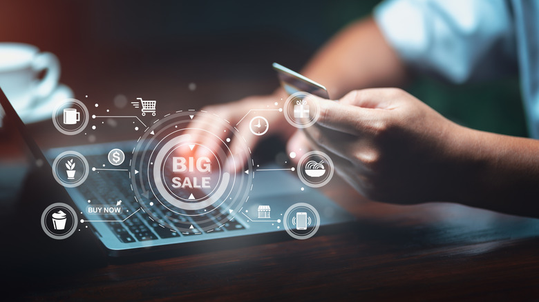 Holographic shopping icons above a laptop