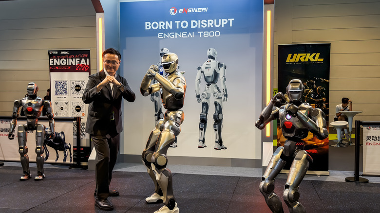 A tech expo in China showing humanoid robots posing alongside a visitor