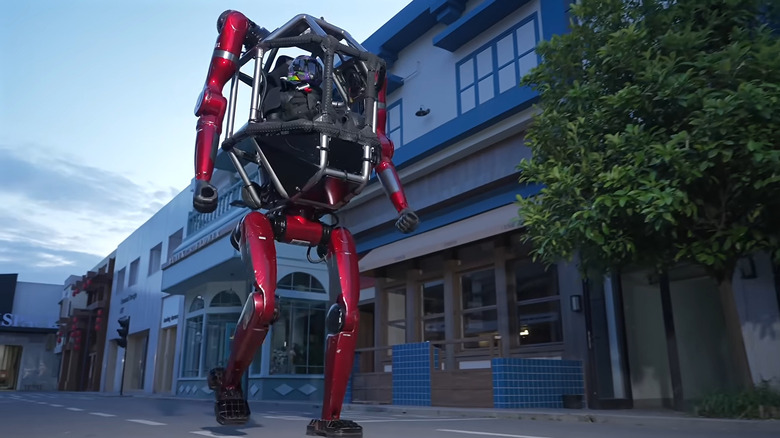 The GD01 robot walking down a street, with a helmeted pilot in the cockpit