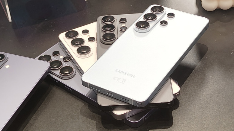 Four different color models of Samsung Galaxy S26 Ultra, all piled on top of each other on a black desk.