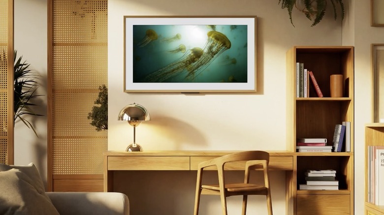 An Amazon Ember Artline TV framed on a wall above a desk.