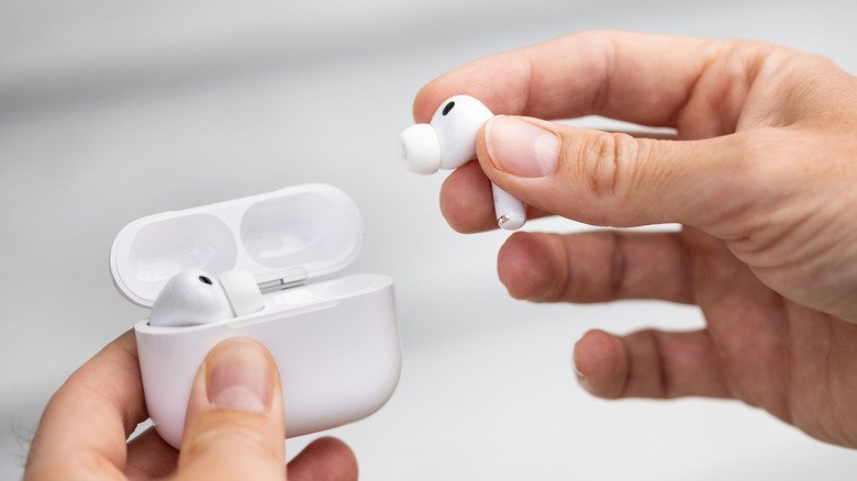 A person holding the Apple AirPods Pro 3 wireless earbuds and their charging case.