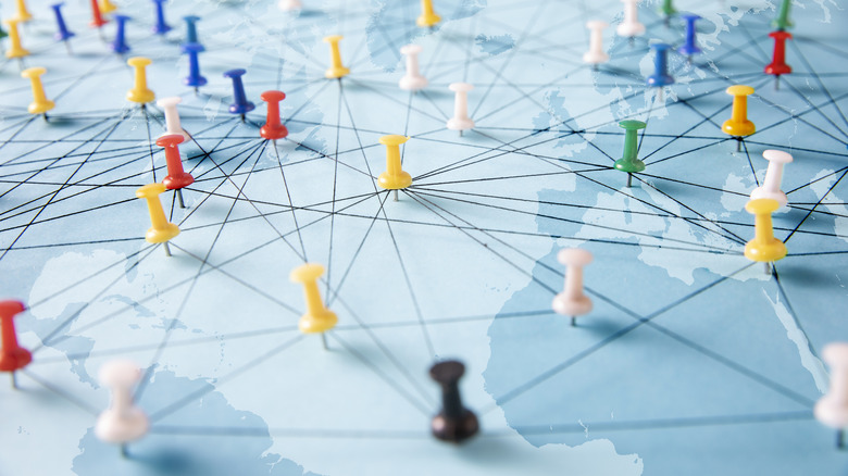 Colorful pushpins indicating locations on a world map.