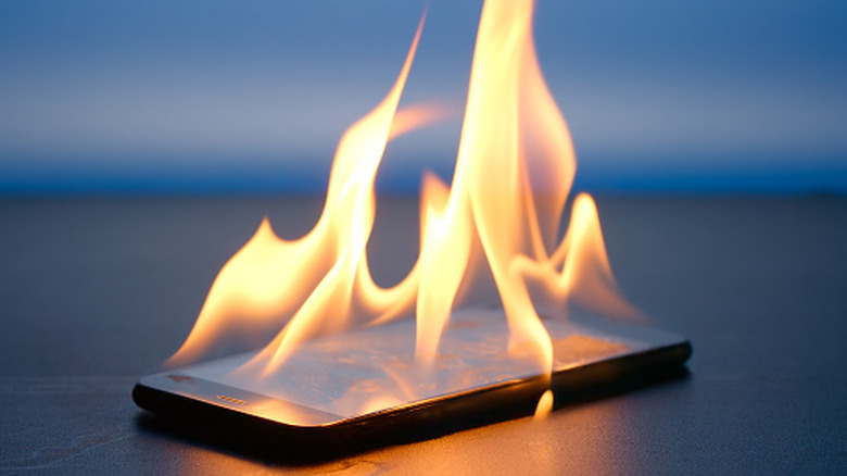 A smartphone catching fire on a flat surface.
