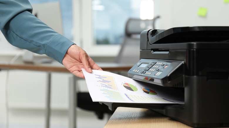 Man taking printout from a modern printer