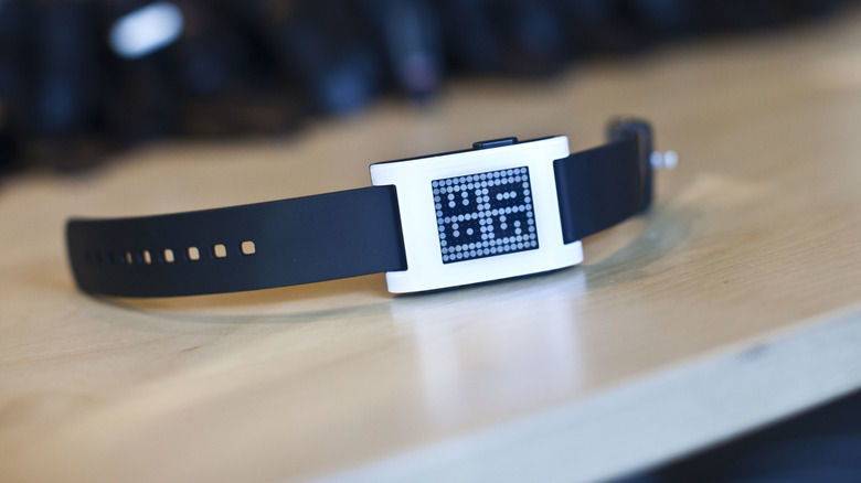A Pebble smartwatch on a wooden table