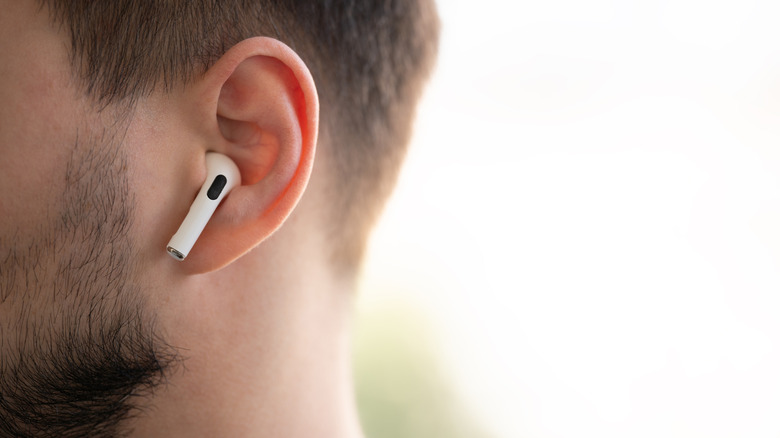 A wireless bud is visible in a man's ear.