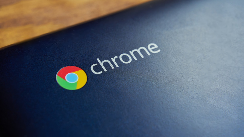 The Chrome logo is visible on the back of a Chromebook laptop in closeup.