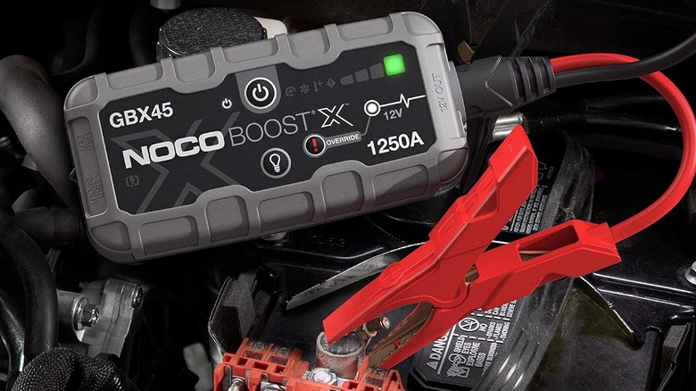The Noco GBX45 sitting on top of a car battery