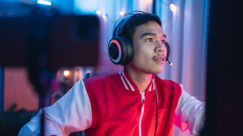 A man in headphones focused on the screen in front of him