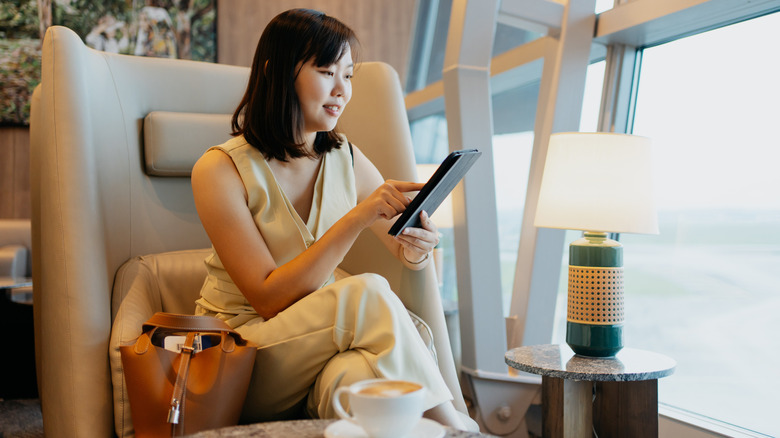 A person using their tablet at an airport lounge.