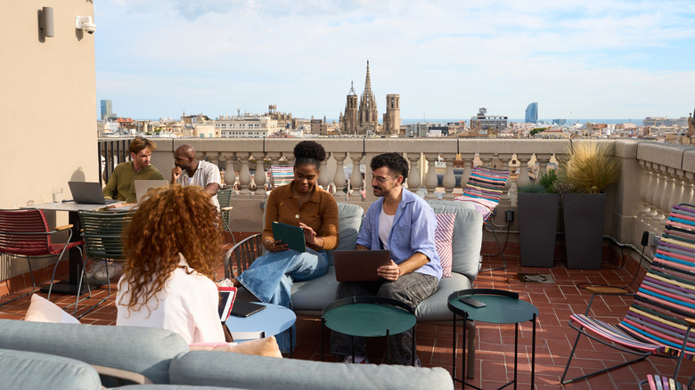 Digital nomads working together in a rooftop setting.