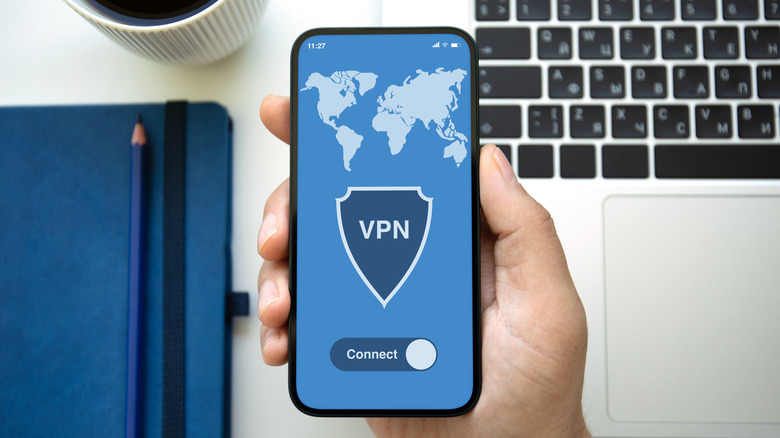 A person holding a smartphone with an a VPN app loaded on the screen.