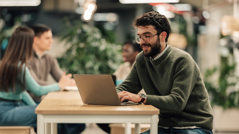 A person working on a laptop at a coworking space.