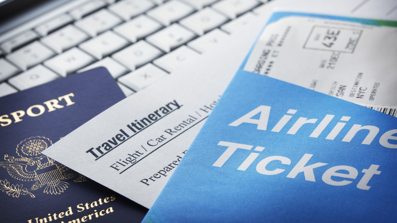 Travel documents on top of a laptop.