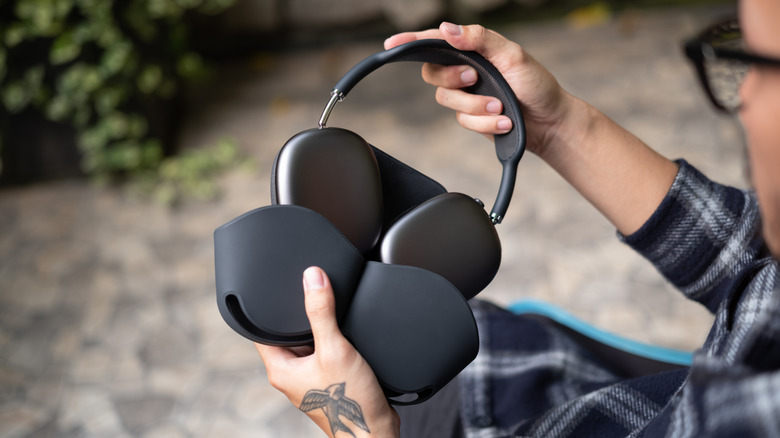 A person pulls a set of AirPods Max from its case.