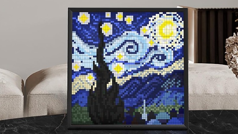 The Divoom Pixoo 64 pixel digital frame showing a painting on the screen.