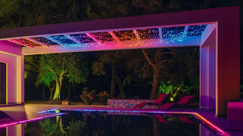 The Twinkly Strings smart string lights installed outdoors, above a swimming pool.