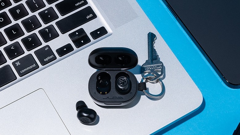 The JLab JBuds Mini earbuds  on top of a MacBook.