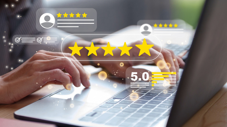 Multiple graphics representing five-star ratings and reviews superimposed over two hands using a laptop.