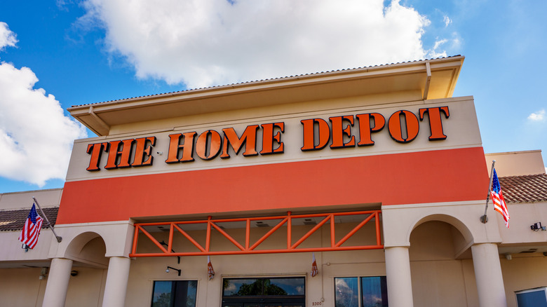A Home Depot storefront in front of a blue sky with white clouds.