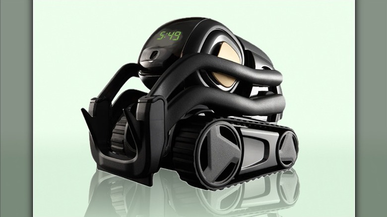 Anki Vector 2.0 against a pastel green background showing 5:49 time on its screen.
