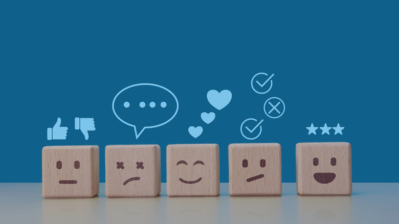 Wooden cube blocks with different expressions engraved onto them.