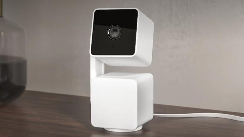 The Wyze Cam Pan V3 security camera on a wooden desk.