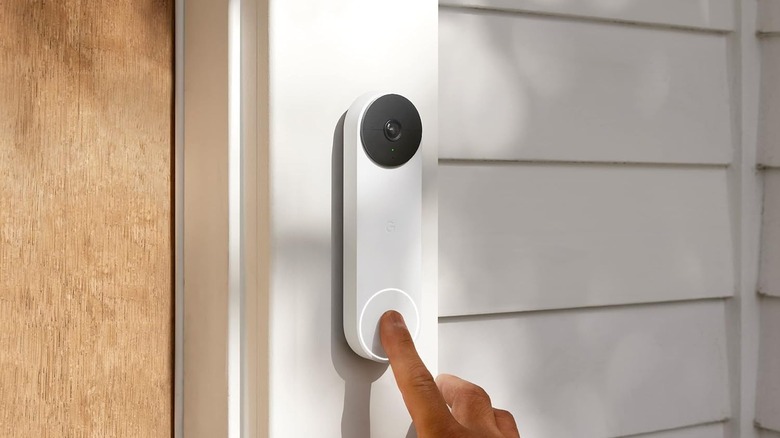 A person pressing the Google Nest Doorbell (Battery) video doorbell.
