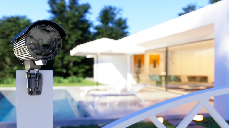 An outdoor security camera on the gate of a house.