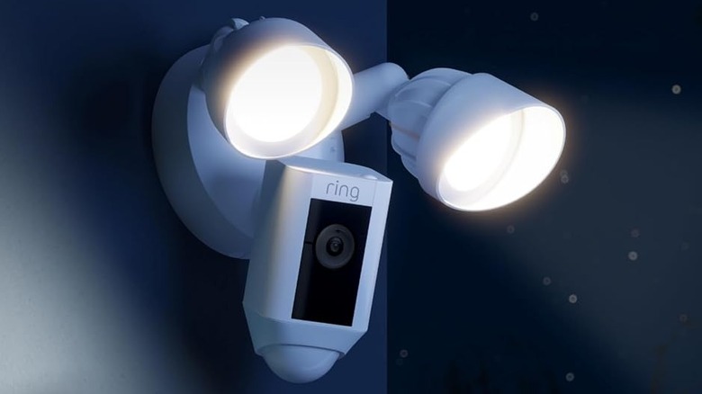 The Ring Floodlight Cam Wired Plus security camera with its lights on at night.