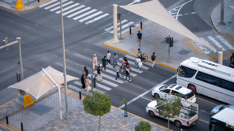 Pedestrians crossing the street before the waiting traffic