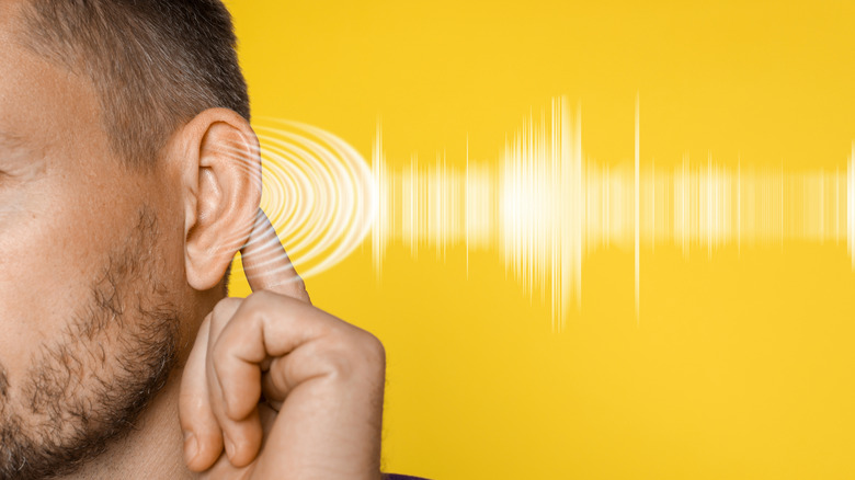 Representation of soundwaves directed toward a man's ear