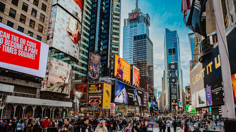A busy street with a crowd and advertisements