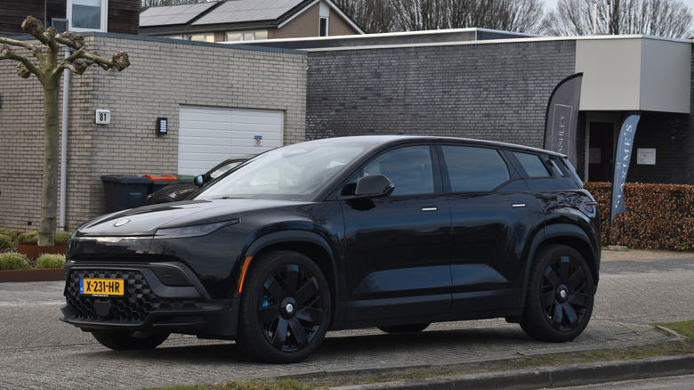 A black 2023 Fisker Ocean parked on the side of a road.