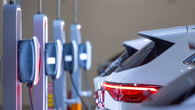 Electric vehicles plugged in at a charging station.
