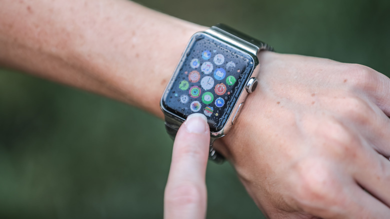Person looking down at their Apple Watch in the rain