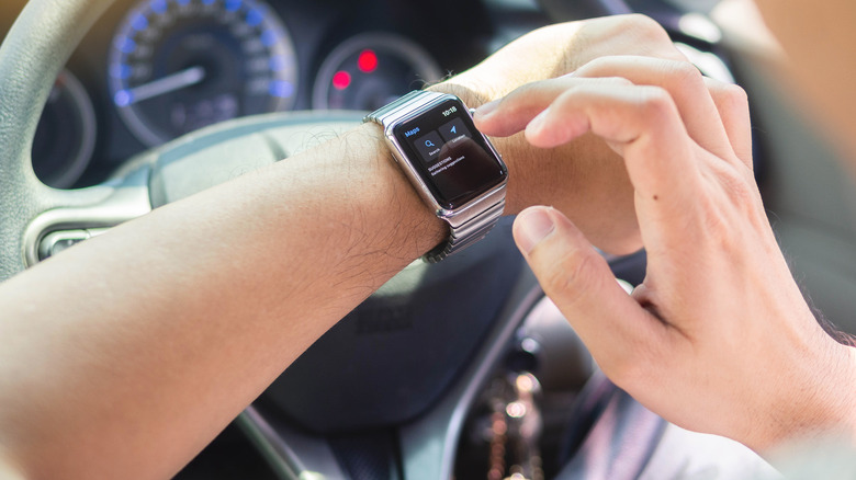 Person looking down at their watch while driving