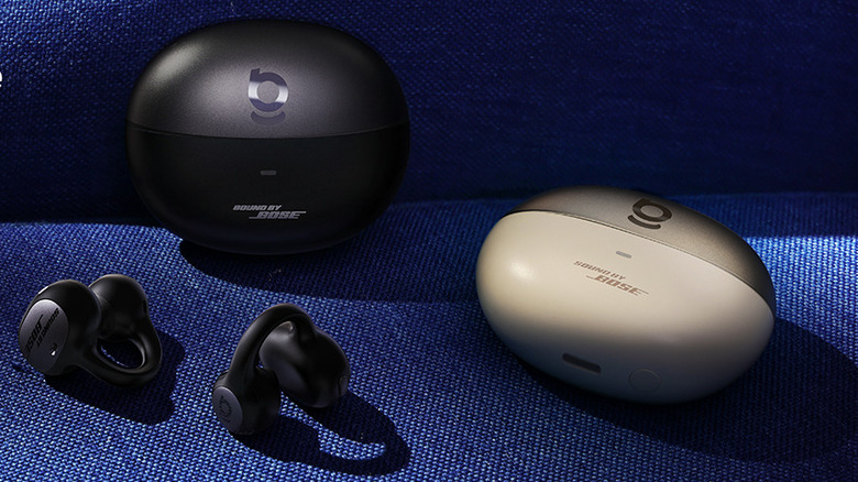 The Baseus Inspire XC1 clip-on earbuds with two of their charging case.