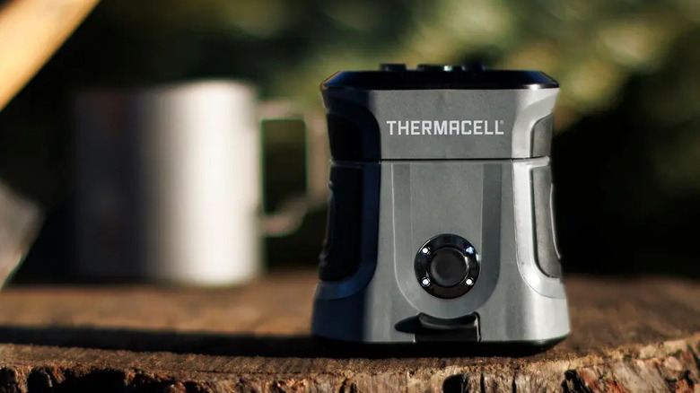 The Thermacell EX90  mosquito repellent placed outdoors on a tree stump.