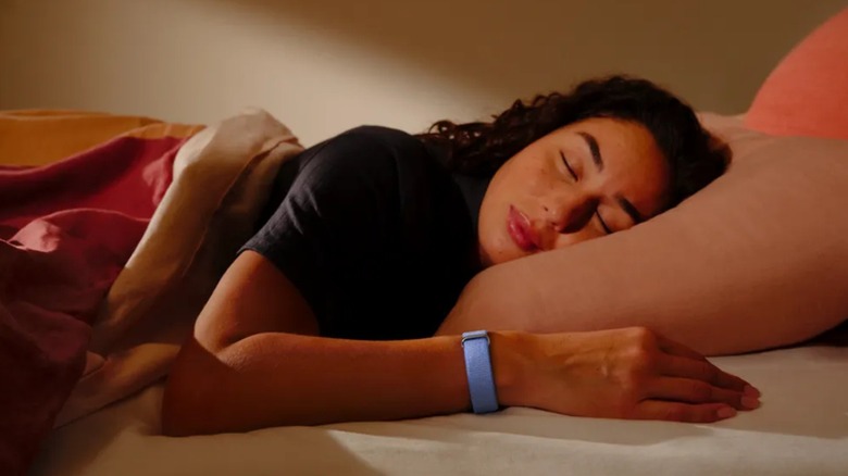 A woman wearing the Google Fitbit Air fitness tracker while sleeping.