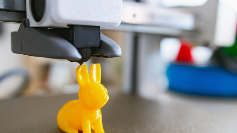 3D printer creating a yellow bunny, similar to models available on the Thangs marketplace.