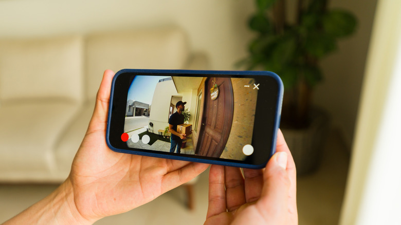A person watching security camera footage using a smartphone app.