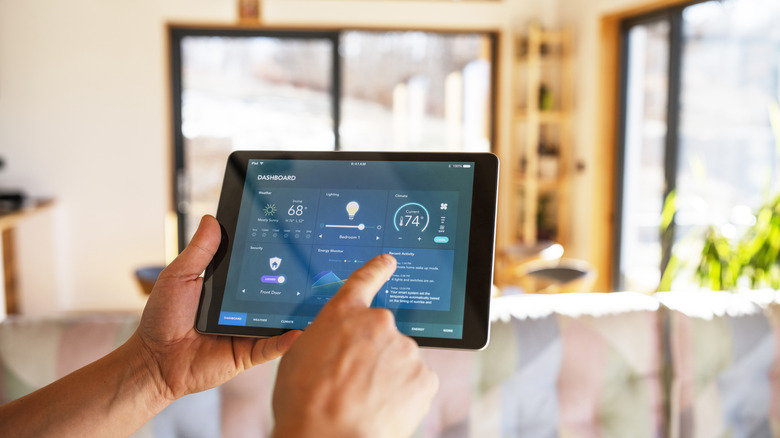 A person using a tablet to access the settings of a smart home device.