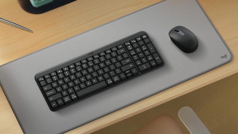 The Logitech MK250 keyboard and mouse, placed on a desk mat on a wooden table