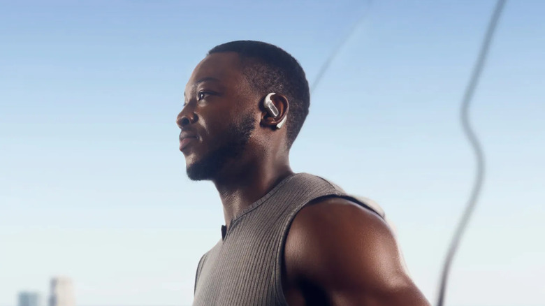 Man jogging with white Shokz Openfit Pro on