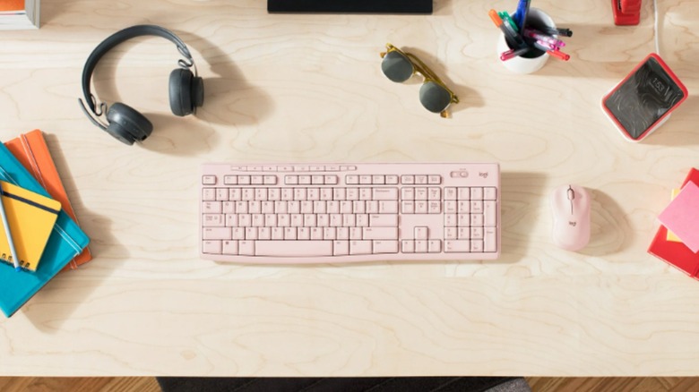 The Logitech Wireless Keyboard and Mouse on a desk among other gadgets