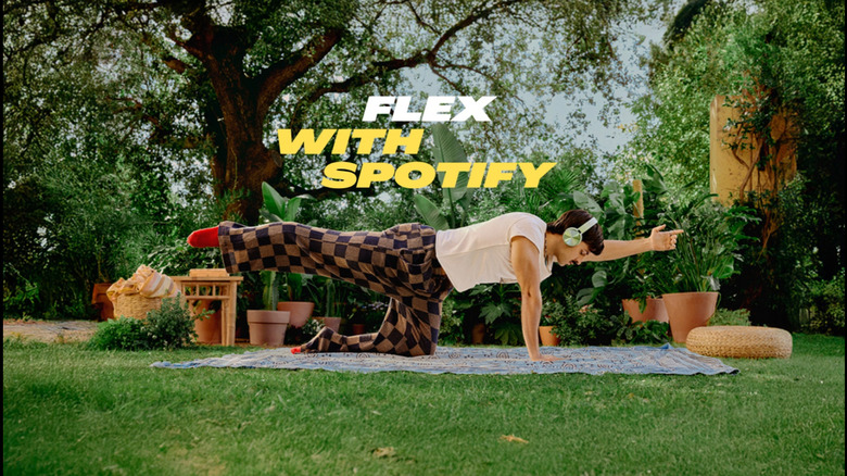 Persona on yoga mat outside listening to music or guided yoga class